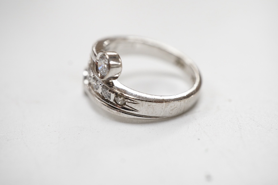 A recent 14k white metal and diamond ring, the ring head designed as three bands, central row of seven graduated diamonds, with two outer collet set diamonds, size G/H.